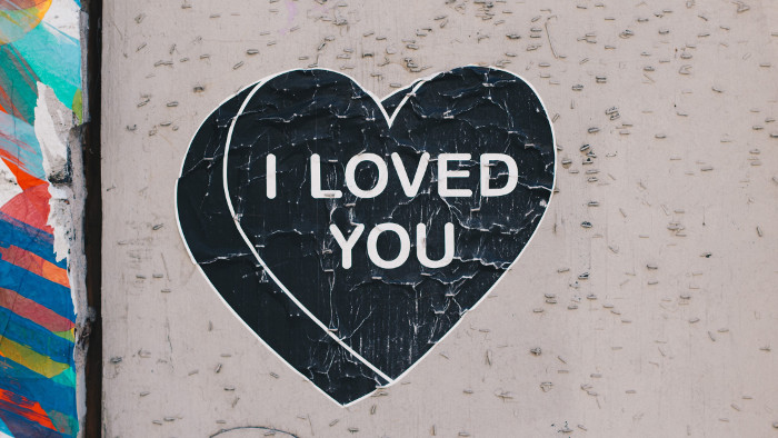 Pared gris con un corazón negro que pone "i love you" haciendo referencia a enamorarte de tu trabajo
