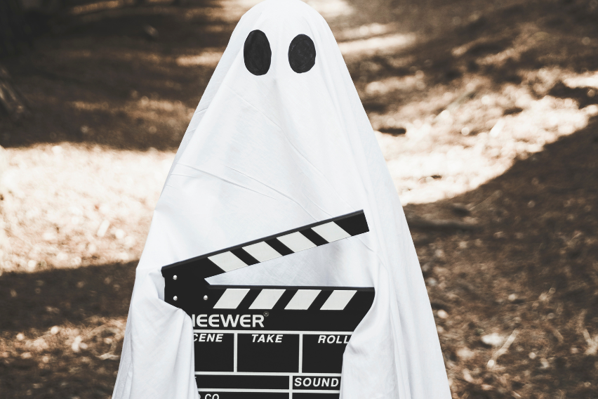 Ghost with a movie clapperboard with the 5 movies that will help you manage your employees