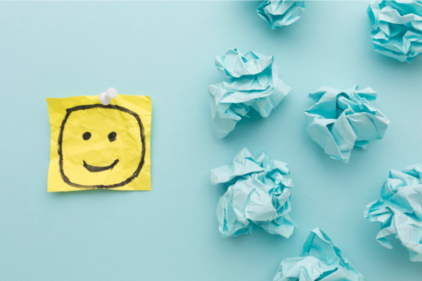Fondo azul con una carita alegre y papeles arrugados