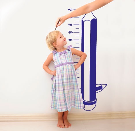 Little girl on a wall with a meter to measure her height